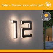 Solar-powered house number with warm white light on grey wall for outdoor lighting