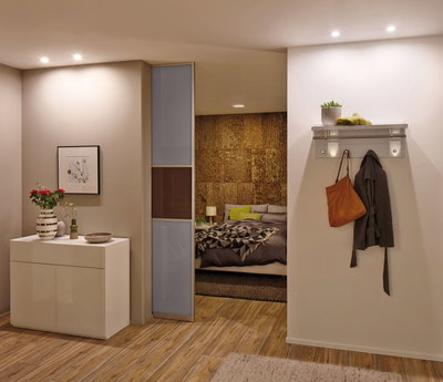 Woonruimte verlicht met warmwitte Paulmann LED-inbouwspots, houten vloer en moderne inrichting