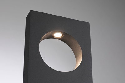 Black metal LED outdoor wall light with round cutout and warm white light for garden lighting