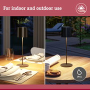 Black metal floor lamp on wooden table, suitable for indoor and outdoor use with IP44 protection rating