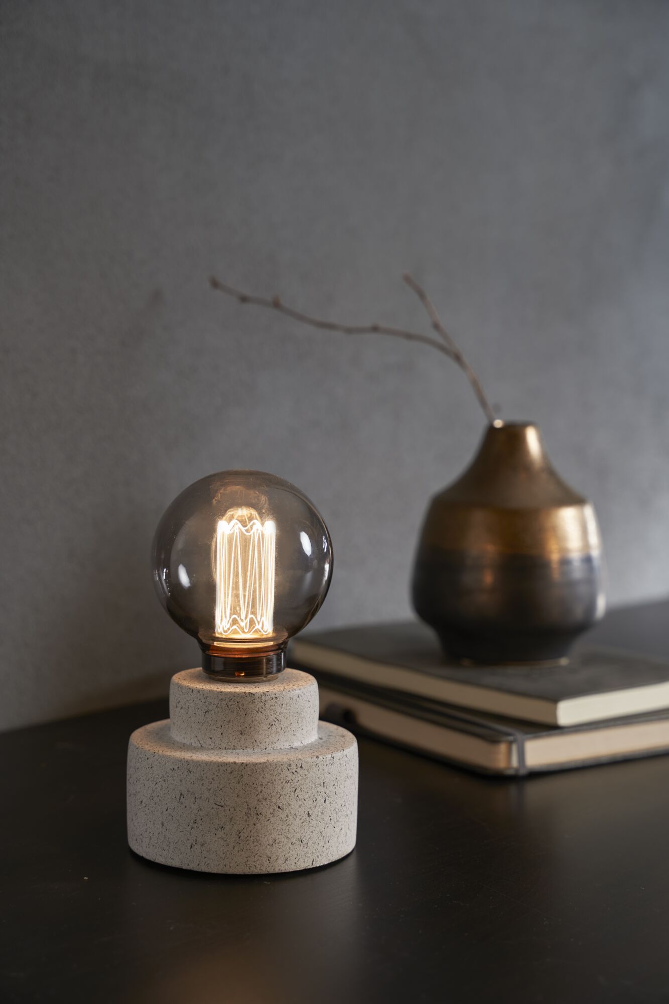 Modern table lamp with round filament bulb on grey stone base for ambient home lighting