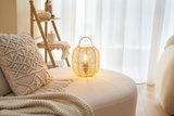 Round beige sofa with macrame cushion and round bamboo table lamp for cozy living room lighting