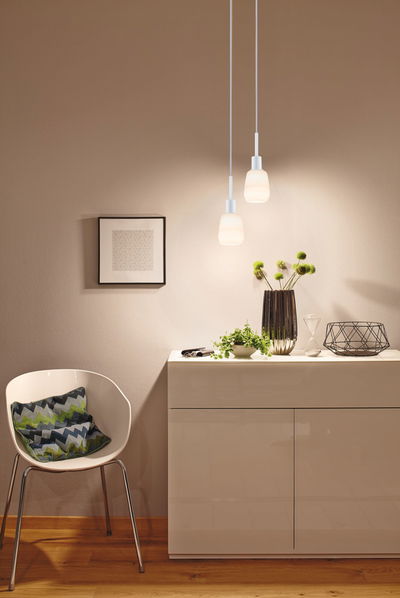 Modern white pendant lights with frosted glass above cream sideboard in living room with wooden floor