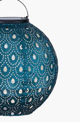 Round blue paper lantern with perforated pattern and metal handle for ambient lighting.