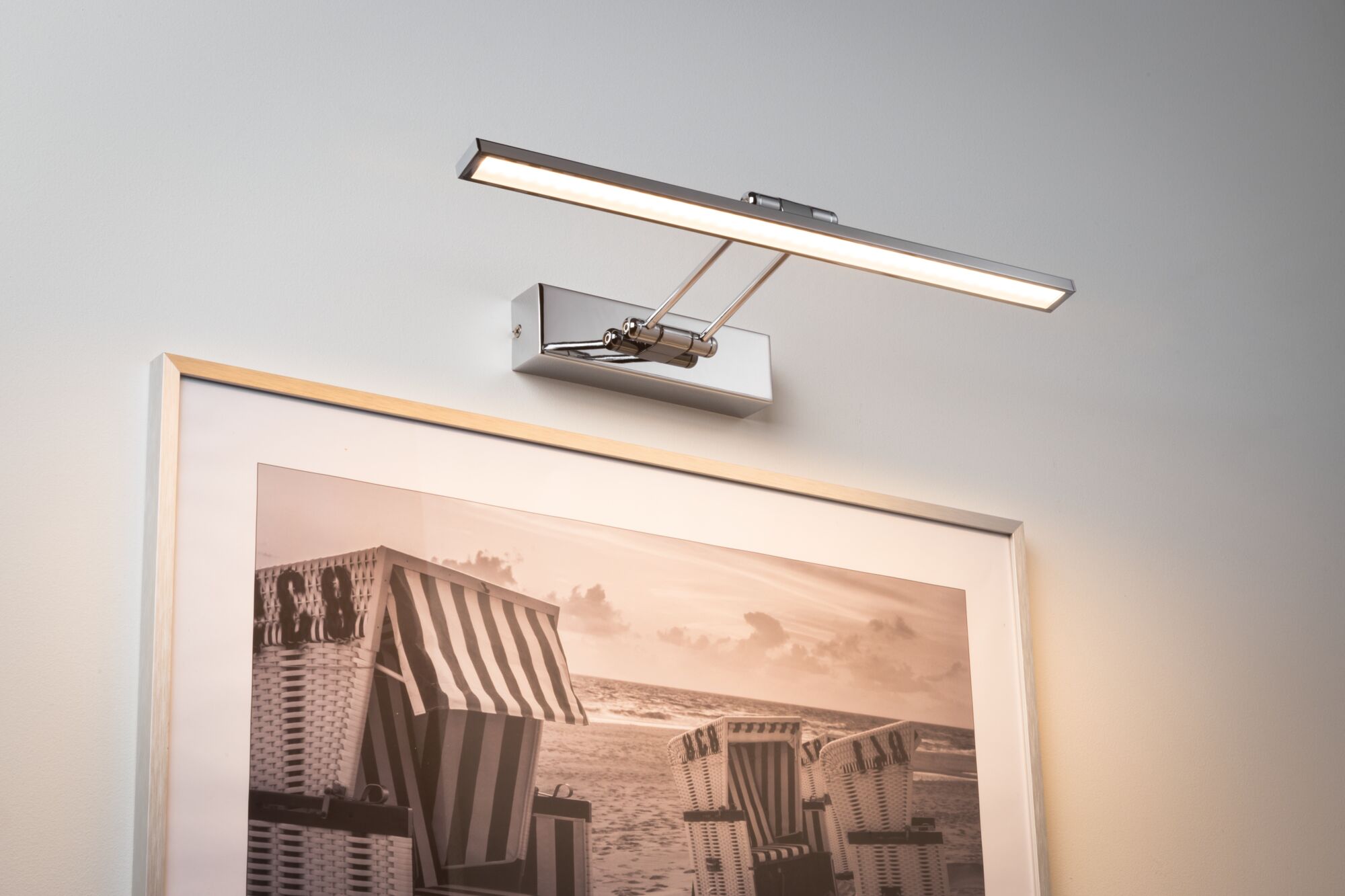 Moderne LED-Bilderleuchte aus verchromtem Metall mit warmweißem Licht für Wandbilder.