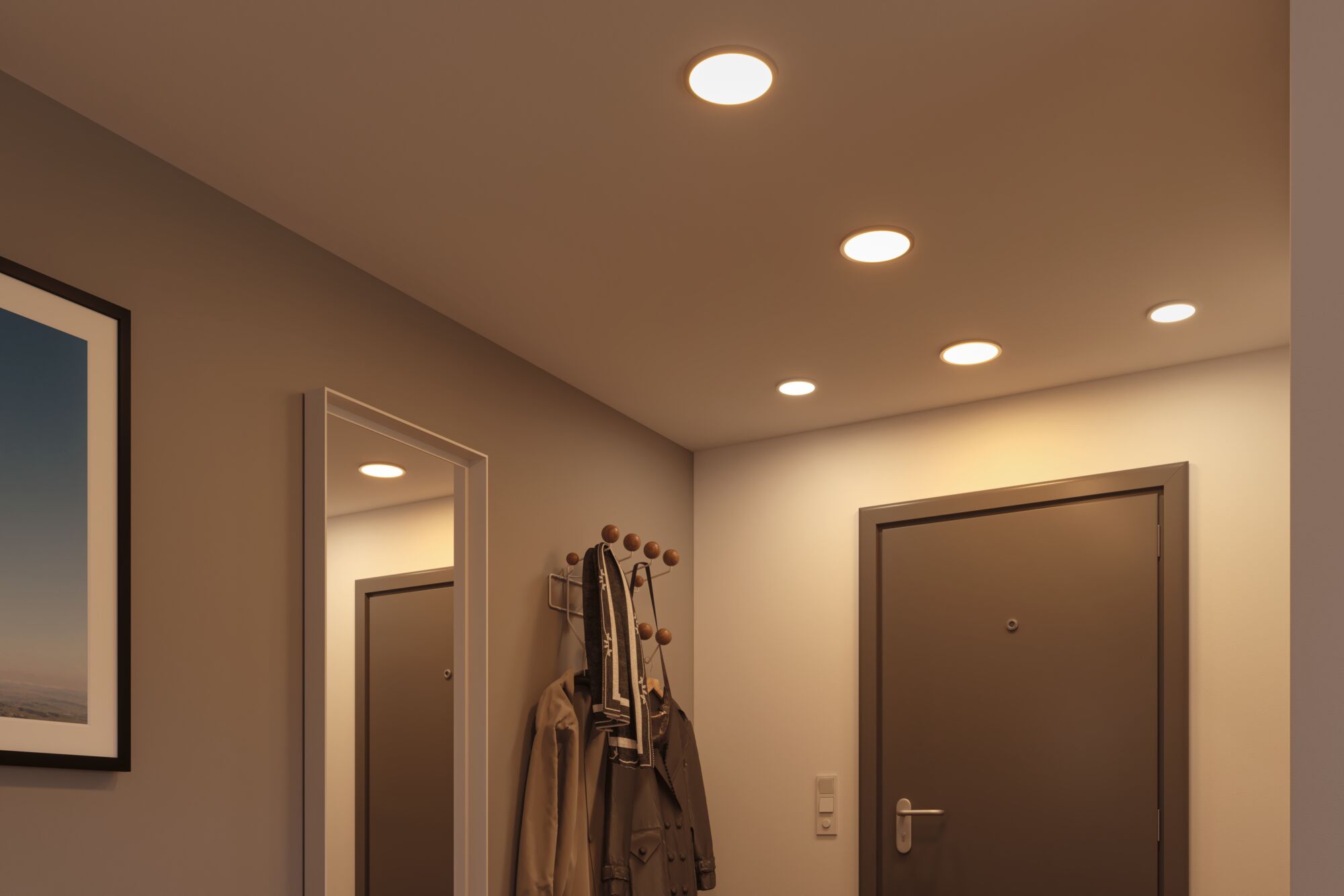 Spots LED encastrés chauds dans un couloir avec porte marron et porte-manteau en bois et métal.