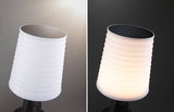 White ribbed plastic solar light with black solar panel, shown unlit and lit at night