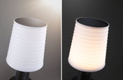 White ribbed plastic solar light with black solar panel, shown unlit and lit at night