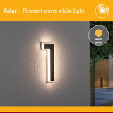 Solar-powered house number 1 with warm white light on grey wall for outdoor lighting