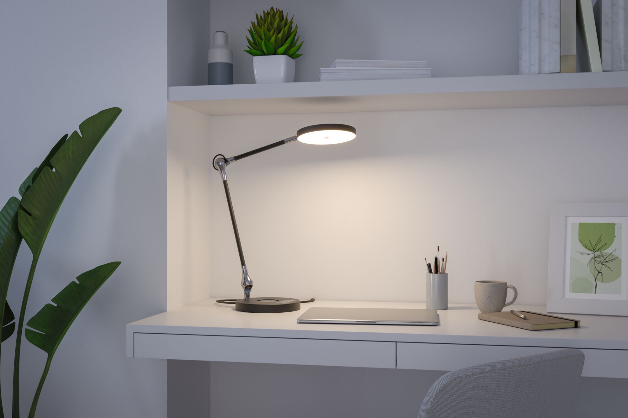 Moderne sort LED skrivebordslampe med rund lyskilde på hvid arbejdsplads med bærbar og kop