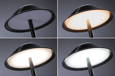 Quatre vues d'une lampe sur pied LED noire avec couleur de lumière réglable et diffuseur blanc.