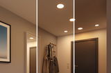 Trois niveaux de spots LED encastrés blanc chaud dans un couloir moderne avec porte-manteau et porte sombre