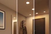 Drei Stufen warmweißer LED-Einbaustrahler in modernem Flur mit Garderobe und dunkler Tür