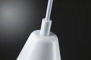 Gros plan d'un abat-jour blanc en métal avec connexion de câble sur fond sombre