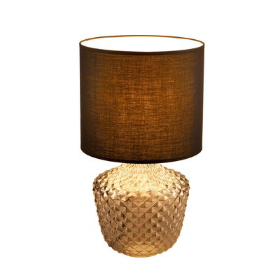 Table lamp with brown fabric shade and textured amber glass base for ambient home lighting
