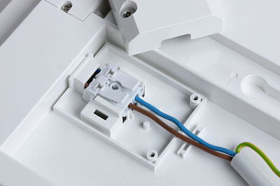 White plastic housing with electrical terminal block and brown, blue wires for LED lighting connection