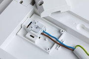 Weißes Kunststoffgehäuse mit elektrischer Anschlussklemme und braunem, blauem Kabel für LED-Beleuchtung