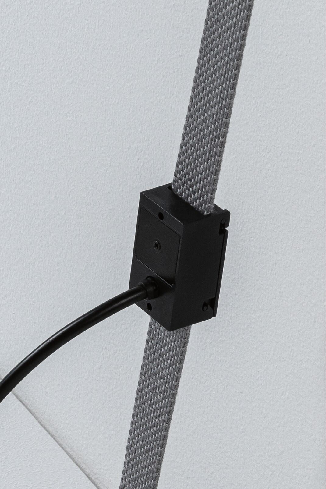 Schwarzes elektrisches Anschlussgehäuse an grauem Textilkabel für LED-Beleuchtungssysteme