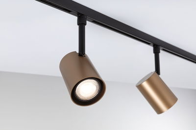 Two gold metal LED spotlights on black track for modern indoor lighting and home decor