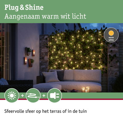 Gezellig terras met warm wit LED-lichtsnoer aan groene haag voor sfeervolle tuinverlichting