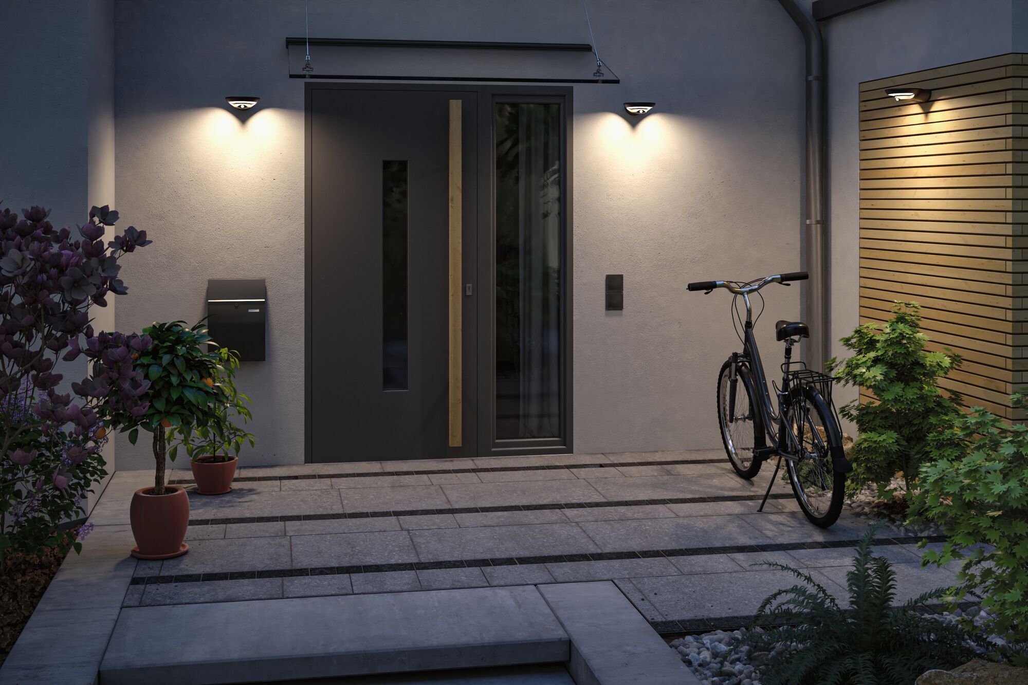 Three modern black wall lights with warm white light at house entrance with bike and plants.