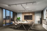 Modern conference room with grey chairs, large table, and adjustable silver ceiling spotlights.