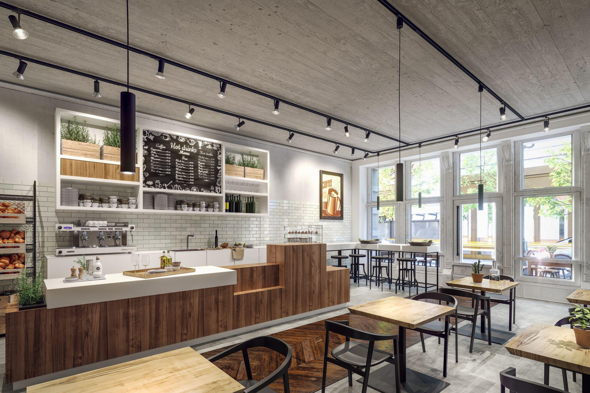 Modern café interior with wooden counter, white tiles, and black pendant lights on concrete ceiling