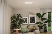 Salon moderne avec plafonnier rectangulaire blanc, fauteuil vert et grandes plantes d'intérieur