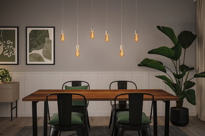 Moderne spisestue med træbord, sorte metalstole og varme LED-hængelamper til boligbelysning.