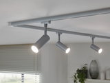 Trois spots LED argentés sur rail de plafond pour éclairage intérieur moderne