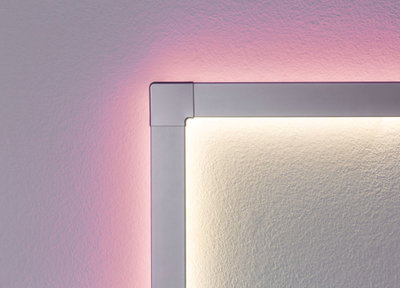 Eckdetail einer silbernen LED-Wandleuchte mit warmweißem Licht und rosa Hintergrundbeleuchtung