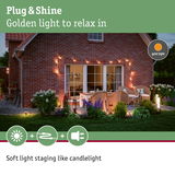 Cozy patio with golden Plug & Shine lights creating soft, candlelight-like outdoor ambiance