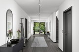 Moderner Flur mit grauem Boden, weißen Wänden, schwarzer Kommode und Paulmann LED-Deckenstrahlern.