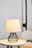 Modern table lamp with black metal frame and light fabric shade on white side table in living room