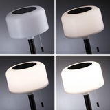 Lampe solaire moderne avec abat-jour en plastique blanc et tige noire, différents niveaux de luminosité.