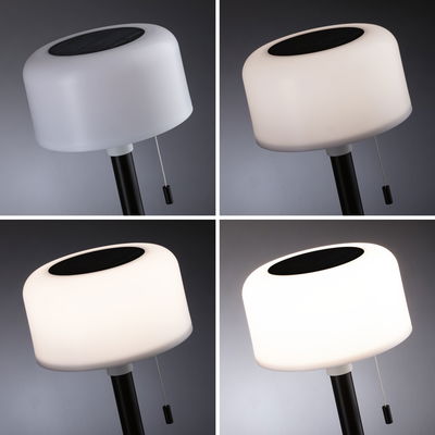 Lampe solaire moderne avec abat-jour en plastique blanc et tige noire, différents niveaux de luminosité.