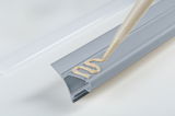 Grey plastic cover strip with beige adhesive applied for easy installation and cable protection.
