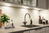 Moderne køkkenbordplade med sort vask, mat sort vandhane og LED underkabinetbelysning