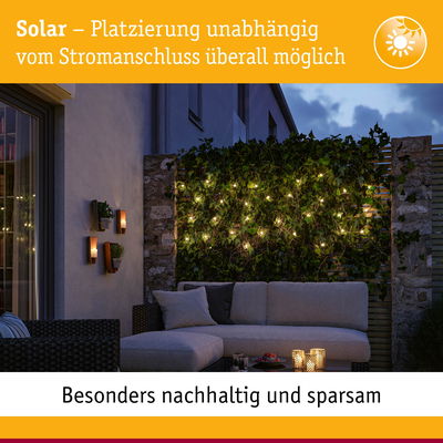Gemütliche Terrasse mit solarbetriebenen Lichterketten an grüner Hecke und nachhaltiger Außenbeleuchtung