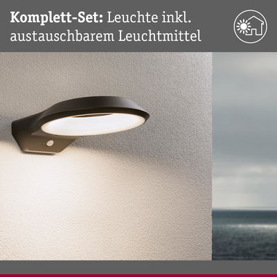 Schwarze Außenwandleuchte mit integriertem Leuchtmittel an heller Wand, wetterfeste LED-Beleuchtung