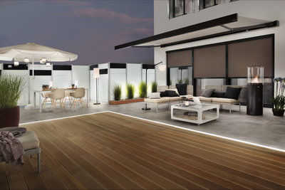 Terrasse moderne avec terrasse en bois, éclairage LED au sol, mobilier lounge et lampes sur pied extérieures