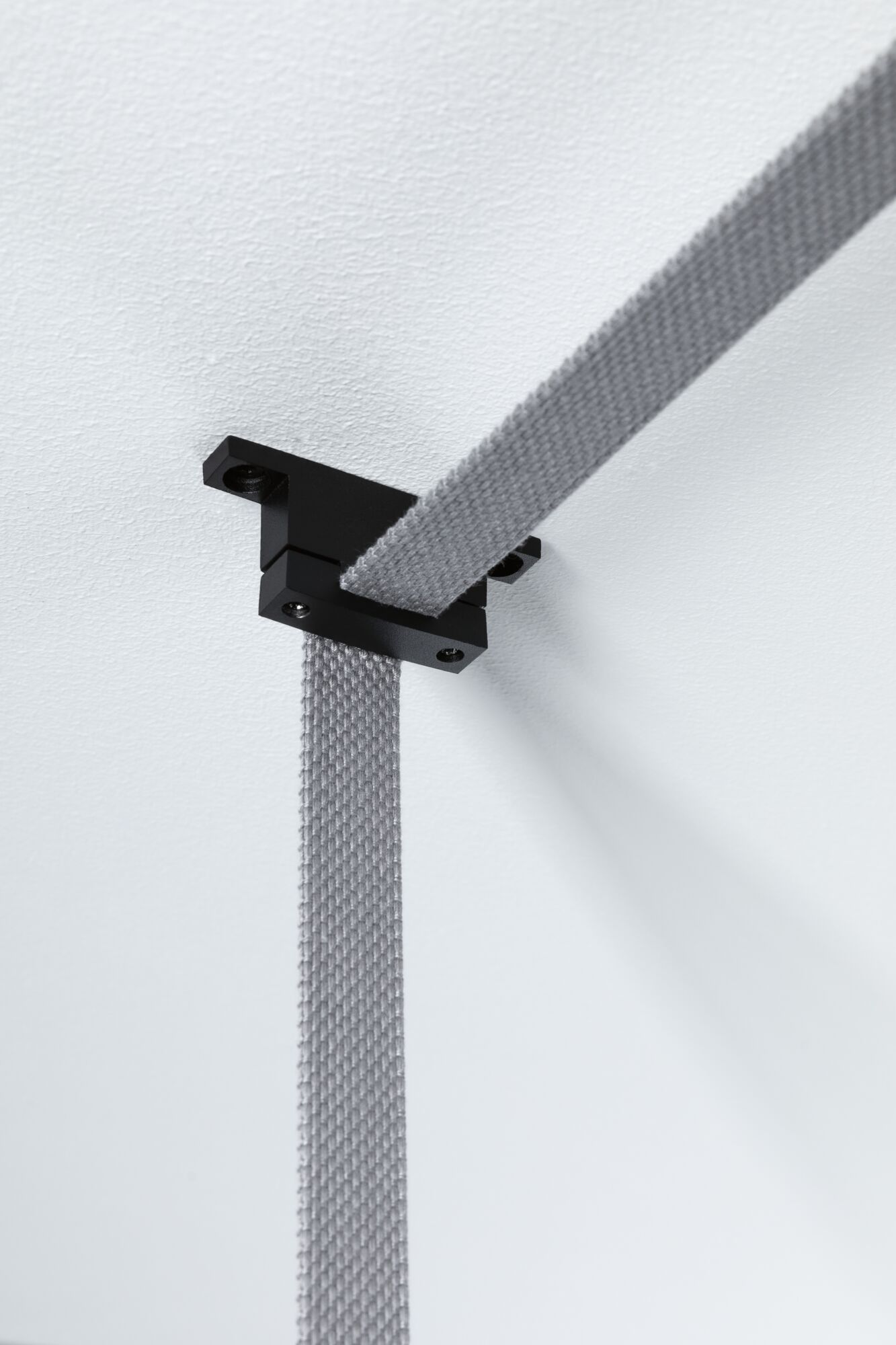 Schwarze Deckenhalterung mit grauem Textilband für flexible Beleuchtungssysteme von Paulmann.