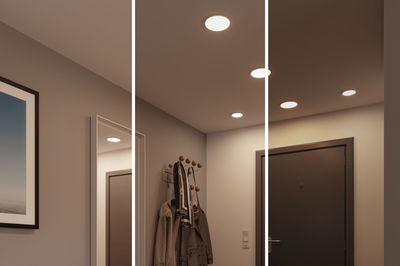 Drei weiße LED-Deckenleuchten in modernem Flur mit Garderobe und dunkler Tür, warmweißes Licht
