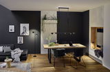 Modern dining area with black metal LED pendant and floor lamp in stylish living room setting.