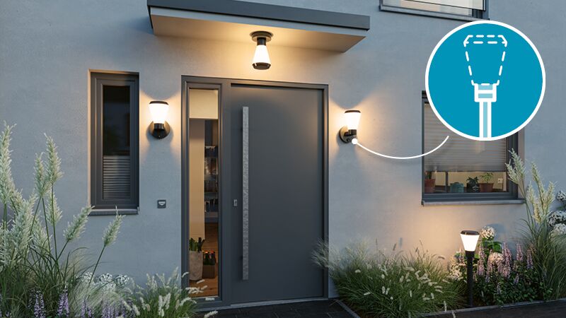 Modern outdoor lighting with three warm white lamps by grey front door and garden plants