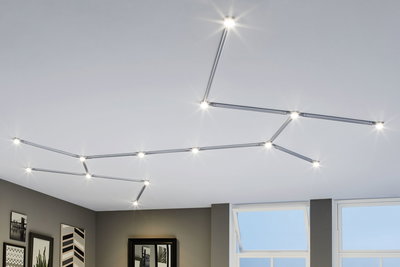Modular LED ceiling light with silver aluminium frame and warm white light in modern living room setting.