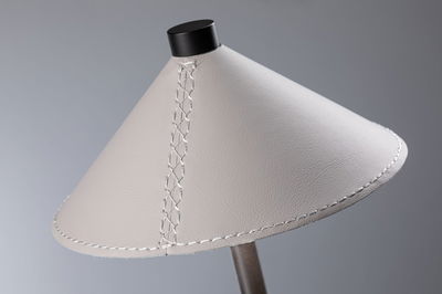 Modern lampshade in light grey leather with decorative stitching and black top ring