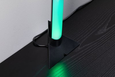 Zwarte LED-vloerlamp met groen licht op donkere houten tafel voor moderne verlichting