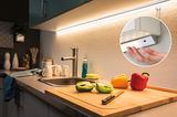 White LED under-cabinet light with warm white glow above kitchen sink and cutting board with peppers