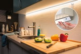 LED-Unterbauleuchte in Weiß mit warmweißem Licht über Küchenspüle und Schneidebrett mit Paprika